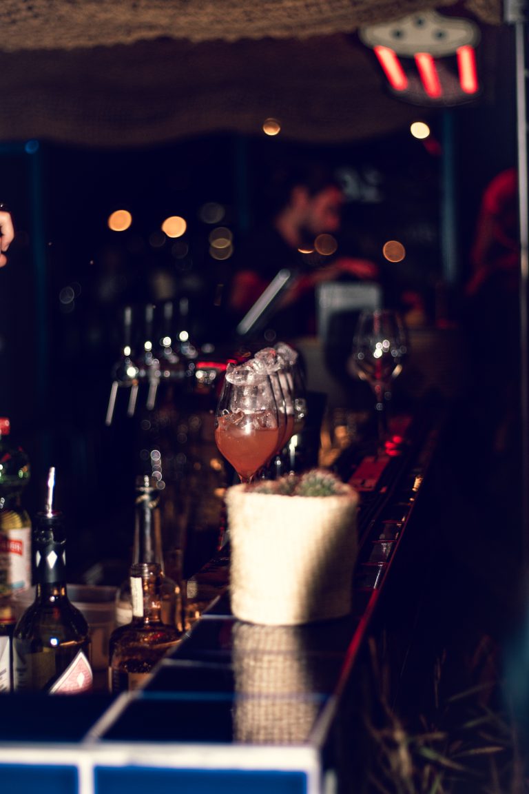 Verre de spritz français rempli de glaçons sur un comptoir de bar en ambiance tamisée